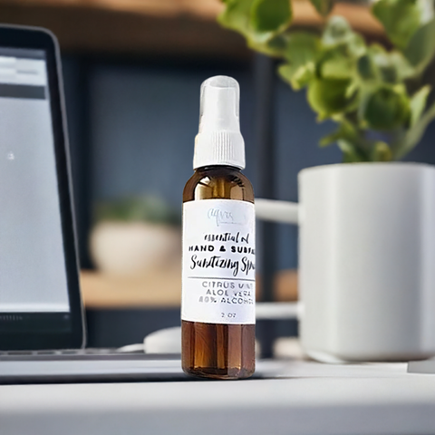 Aqualime Hand and Surface Sanitizing Spray on a glass surface with a laptop and coffee cup in the background, creating a productive, hygienic workspace