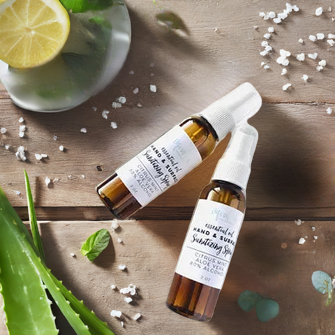 Aqualime Hand and Surface Sanitizing Spray on a wooden surface with an aloe vera leaf and sliced lemon, highlighting its refreshing, moisturizing properties.