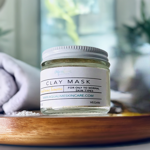 Aqualime Turmeric and Clay Facial Mask bottle placed on a wooden table with a blurry background and white towel, highlighting its all-natural brightening benefits