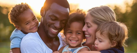 A black man and a white woman with their three multiracial children, smiling together as a family