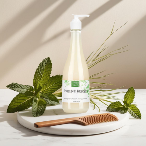 Brown Butter Beauty Detangling Leave-In Conditioner bottle on a white surface with a green leaf and hair comb, reducing frizz and adding shine