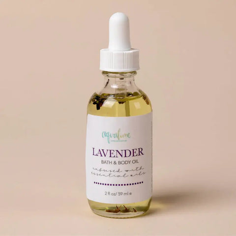 Aqualime Lavender Bath and Body Oil bottle placed on a soft light pink background, highlighting its calming lavender scent and hydrating, natural ingredients