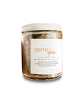 Aqualime Coffee Glow Shimmering Sugar Body Scrub in a glass bottle against a clean white background, highlighting its natural coffee, cinnamon, and gold mica ingredients for glowing skin