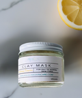 Aqualime Turmeric and Clay Facial Mask bottle placed on a white background with cut lemon, showcasing its brightening and skin-rejuvenating properties