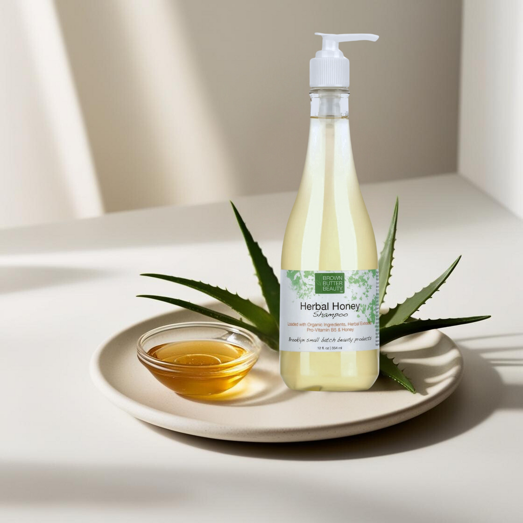 Brown Butter Beauty Herbal Honey Shampoo bottle placed on a plate with aloe vera leaf and oil, highlighting its gentle cleansing and nourishing properties for hair