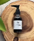 R. Drew Clear Skin Charcoal Face Wash bottle placed on a wooden plate with aloe vera leaf, a vegan face wash for oily and acne-prone skin